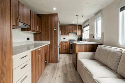 Intérieur d'un mobil-home haut de gamme avec finitions bois et métal brossé, illustrant la qualité de fabrication d'un constructeur premium